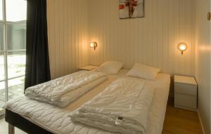 a bedroom with two beds with white sheets at Nice Home In Grenaa With Sauna in Grenå +16 photos