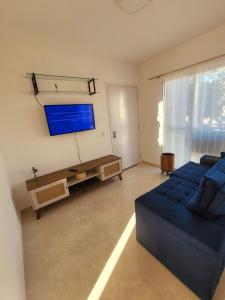 a living room with a blue couch and a flat screen tv at Apartamento com estacionamento in Uruguaiana