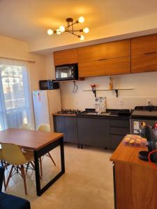 a kitchen with a table and a kitchen with a refrigerator at Apartamento com estacionamento in Uruguaiana