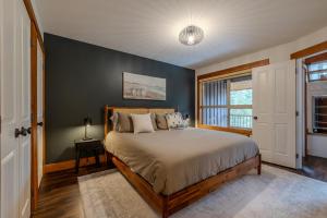 a bedroom with a bed and a blue wall at Fully Renovated Penthouse Loft at Fernie Alpine Resort in Fernie