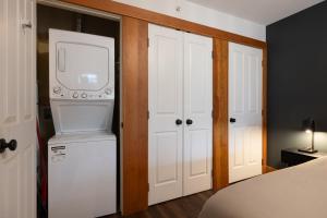 a bedroom with a bed and a television and a refrigerator at Fully Renovated Penthouse Loft at Fernie Alpine Resort in Fernie +28 photos