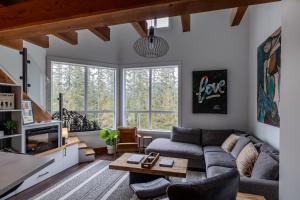 a living room with a couch and a table at Fully Renovated Penthouse Loft at Fernie Alpine Resort in Fernie