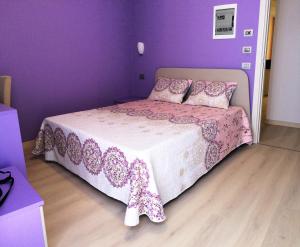 ポテンツァにあるBorgo Chianaraの紫の壁のベッドルーム1室