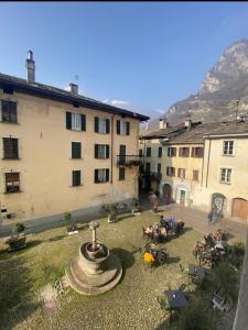 a group of people sitting around a courtyard with a fountain at Casa Vacanze La Romantica in Chiavenna