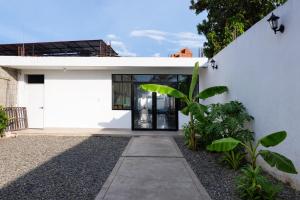 a white house with a door and some plants at La casa de Isabel in Tarapoto