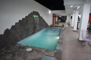 a swimming pool with a waterfall in a building at La casa de Isabel in Tarapoto