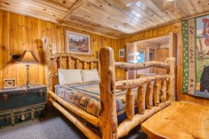ein Schlafzimmer mit einem Bett in einer Blockhütte in der Unterkunft Pine Haven Resort in Estes Park