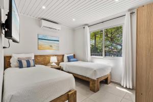 a bedroom with two beds and a window at Salinja Cerca 2-B in Palm-Eagle Beach +77 photos