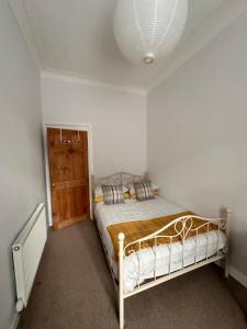a bedroom with a bed in a white room at Castle Brae Apartment in Stirling