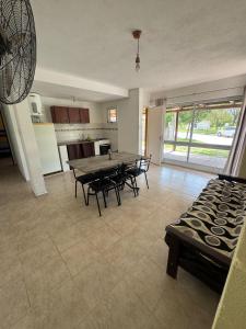 a kitchen and living room with a table and chairs at Complejo El Teyu in Miramar