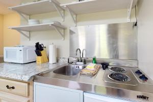 a kitchen with a sink and a microwave at Inviting & Cozy Studio Sleep 4 Shared Gym & Games in Baneberry