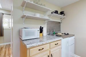 a kitchen with a microwave and a sink at Inviting & Cozy Studio Sleep 4 Shared Gym & Games in Baneberry