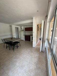 a living room with a table and a kitchen at Complejo El Teyu in Miramar +12 photos
