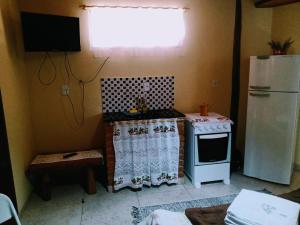 a small kitchen with a stove and a refrigerator at Suites da Dorinha in Visconde De Maua