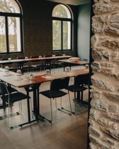 a row of tables and chairs in a room with windows at Hôtel le Corbusson Laval Ouest in Saint-Berthevin-sur-Vicoin +180 photos