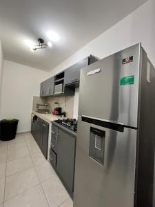 a kitchen with a stainless steel refrigerator and cabinets at Noir Beach Suite in Ciudad Madero