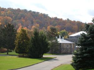 a building in front of a mountain with trees at Auberge de l'Abbaye d'Oka in Oka