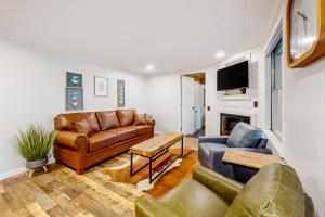 a living room with a leather couch and a tv at Charming Mtn View Cabin Sleeps 8 Spacious Deck in Townsend