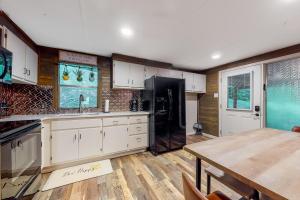 a kitchen with white cabinets and a table and a refrigerator at Charming Mtn View Cabin Sleeps 8 Spacious Deck in Townsend +44 photos