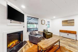 a living room with a fireplace and a flat screen tv at Charming Mtn View Cabin Sleeps 8 Spacious Deck in Townsend