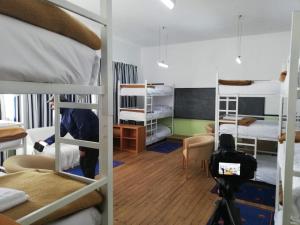 a dorm room with bunk beds and a camera at Lagartoca in Vilar de Amargo
