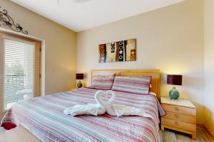 a bedroom with a bed with two swans on it at Charming Condo W Shared Pools Sleeps 6 Playground in Pigeon Forge