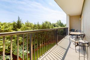 a balcony with a table and chairs and trees at Charming Condo W Shared Pools Sleeps 6 Playground in Pigeon Forge