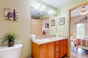 a bathroom with two sinks and a mirror and a tub at Charming Condo W Shared Pools Sleeps 6 Playground in Pigeon Forge