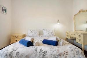 a bedroom with a bed with blue pillows and a mirror at traveller's house PROMO 25 in Machico