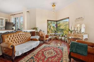 a living room with a couch and chairs and a table at traveller's house PROMO 25 in Machico