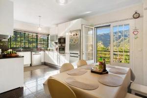 a kitchen with a table and chairs in a kitchen at traveller's house PROMO 25 in Machico