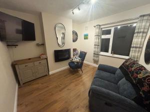 a living room with a couch and a tv at Fiona's Country Accommodation in Murphyʼs Bridge