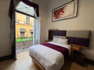 a bedroom with a large bed and a window at Hotel Alhaja Puebla Centro Histórico in Puebla +146 photos