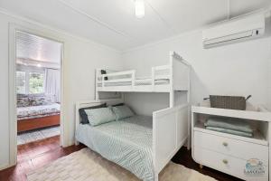 a bedroom with two bunk beds and a window at Barefoot on O'Neil in Lancelin