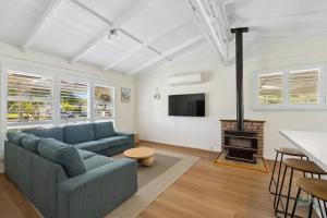 a living room with a blue couch and a fireplace at Barefoot on O'Neil in Lancelin