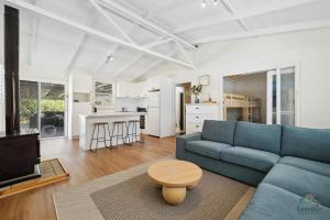 a living room with a blue couch and a table at Barefoot on O'Neil in Lancelin