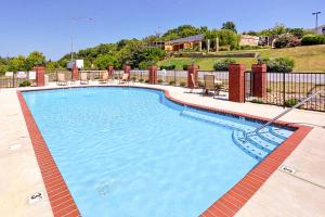 a large swimming pool with chairs and a fence at River View Condo Sleeps 6 Shared Hot Tub & Pool in Pigeon Forge +14 photos