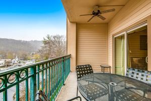 a balcony with a table and chairs and a ceiling fan at Downtown Summit Manor Sleeps 8 Mtn Views Pool in Gatlinburg