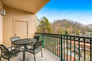 a patio with a table and chairs on a balcony at Downtown Summit Manor Sleeps 8 Mtn Views Pool in Gatlinburg