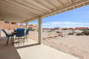 a patio with chairs and a table on the beach at Casa Sonora in Puerto Peñasco