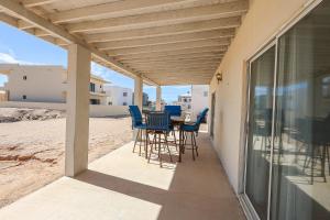 a patio with chairs and a table on the beach at Casa Sonora in Puerto Peñasco