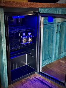 an open refrigerator with bottles of water in it at "The 19th Hole" Luxury Treehouse w Golf Views & Private 20ft Slide - 10 Miles from Dollywood in Sevierville