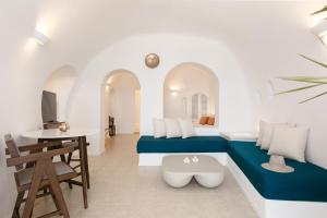 a room with two beds and a table and a desk at Nevma Suites in Firostefani