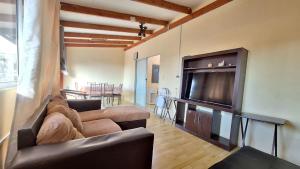 a living room with two couches and a flat screen tv at Casa centro de Arica in Arica
