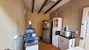 a room with a refrigerator and a large bottle of water at Casa centro de Arica in Arica