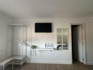 a white room with a television on a wall at Hostal Casa Amalia in Teruel