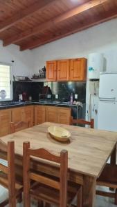 a kitchen with a wooden table and a white refrigerator at El encanto in Santa María