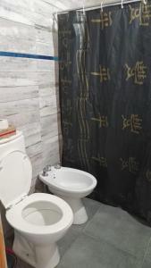 a bathroom with a toilet and a shower curtain at El encanto in Santa María +4 photos