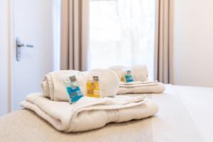 a couple of towels sitting on top of a bed at Prestige Guest House Cambridge Modern Ensuite Rooms in Cambridge