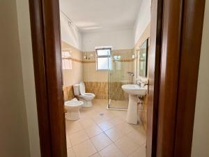 a bathroom with two toilets and a shower and a sink at Hotel Amaiià in Sarandë +37 photos